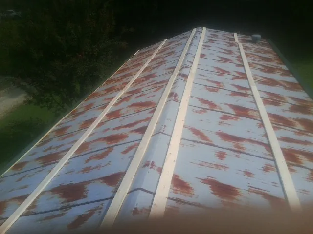 Rusted metal roof panels with new wood purlins before replacement — Storm Damage Roof Repair in Ball Ground by Roofing Brothers